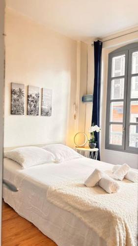 un lit blanc dans une chambre avec une fenêtre dans l'établissement Le Cocon, à Montauban