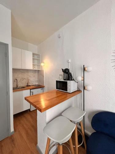 - une petite cuisine avec une table et deux tabourets dans l'établissement Le Cocon, à Montauban