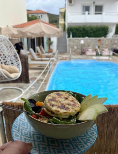 a bowl of food on a table next to a pool at Koukounari Agistri in Skala
