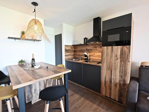 - une cuisine avec un comptoir en bois et une table dans l'établissement Apartment L'Esquinade - G1 203 by Interhome, à Agay