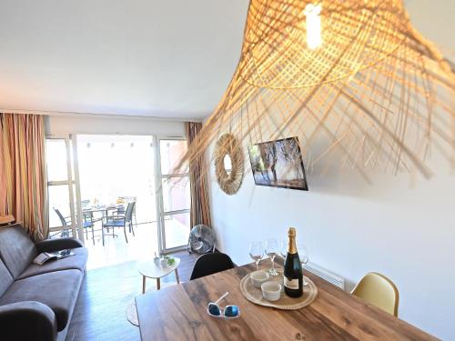 un salon avec une table avec une bouteille de vin dans l'établissement Apartment L'Esquinade - G1 203 by Interhome, à Agay