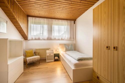 a bedroom with a bed and a desk and a window at Villa Pinie Apt 1 in Terlano