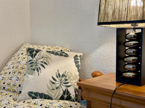 a bedroom with a bed with a pillow and a lamp at Le Val Thibaud in Buncey