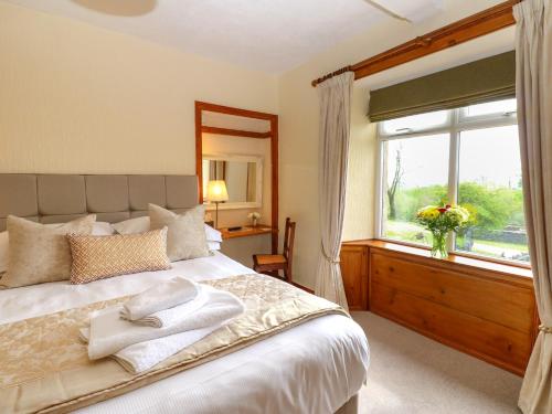 sypialnia z dużym łóżkiem i oknem w obiekcie Longwell House w mieście Grayrigg