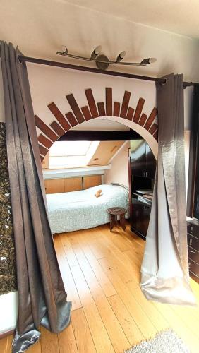 - une chambre avec un lit et un plafond voûté dans l'établissement Coquet 2 pièces sous les toits, à Fresnes