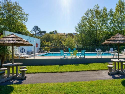 - une piscine avec des chaises, des tables et des parasols dans l'établissement Holiday Home Les 7 Nains-6 by Interhome, à Bidart