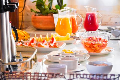 a table topped with plates of food and drinks at VELINN Hotel Fazenda Fonte das Hortênsias in Santo Antônio do Pinhal
