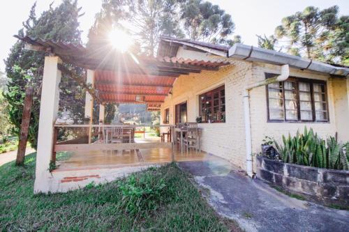 a house with a patio with a table and chairs at VELINN Hotel Fazenda Fonte das Hortênsias in Santo Antônio do Pinhal