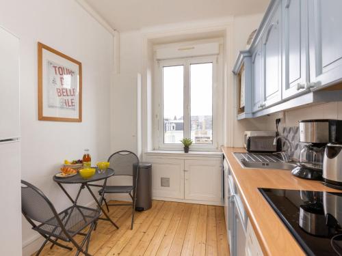 une cuisine avec une table et des chaises et une fenêtre dans l'établissement Apartment La Fontaine by Interhome, à Saint-Malo