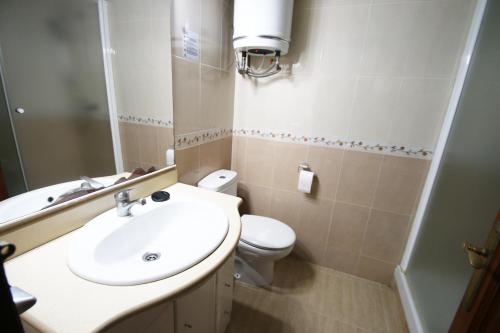 Un baño con un lavabo blanco y un inodoro. en Casas Blancas 26, en Miami Platja