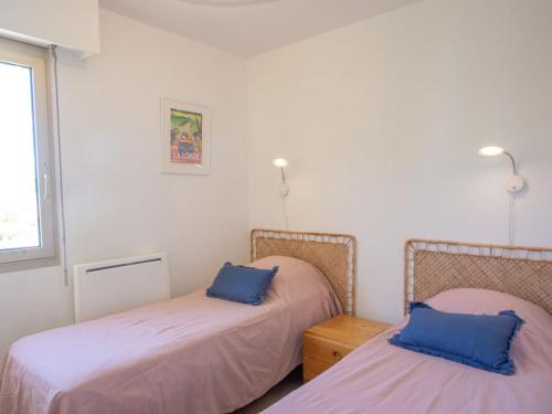 une chambre avec deux lits avec des oreillers bleus dans l'établissement Apartment Aigue Marine by Interhome, à La Londe-les-Maures