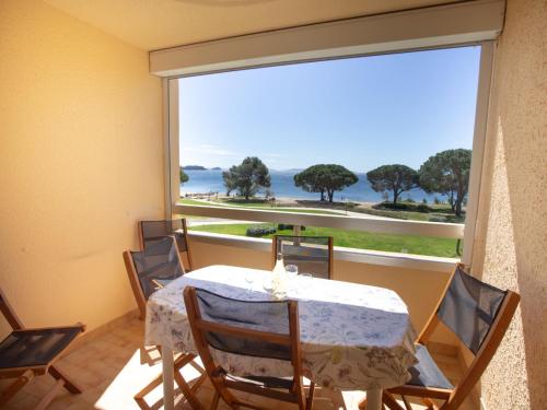 une salle à manger avec une table et une grande fenêtre dans l'établissement Apartment Aigue Marine by Interhome, à La Londe-les-Maures