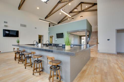 a large kitchen with a counter and stools at Sprawling Kaufman Home with On-Site Lake and Fire Pit in Kaufman