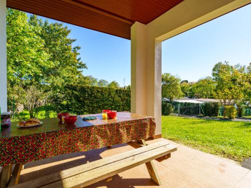 a table and a bench on a screened in porch at Holiday Home Les 7 Nains-5 by Interhome in Bidart