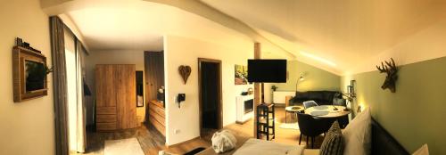 een woonkamer met een bank en een tafel bij Zur neuen Post Landgasthof in Herzogsreut