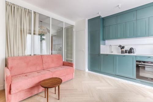 - un salon avec un canapé rose et des armoires bleues dans l'établissement MyKeypers - Design & Cosy Flat 4P - Paris XV, à Paris
