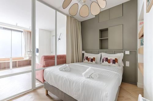- une chambre avec un grand lit blanc et une grande fenêtre dans l'établissement MyKeypers - Design & Cosy Flat 4P - Paris XV, à Paris