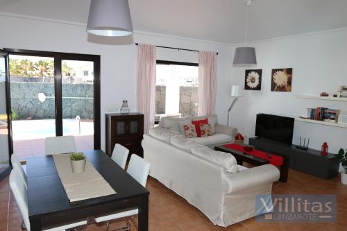 sala de estar con sofá blanco y mesa en VILLA BERMEJA 1 by Villitas, en Playa Blanca