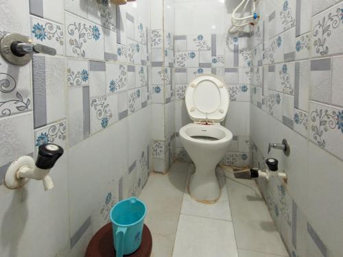 a bathroom with a toilet with blue and white tiles at Infinity Luxury Homestay in Garudeshwar
