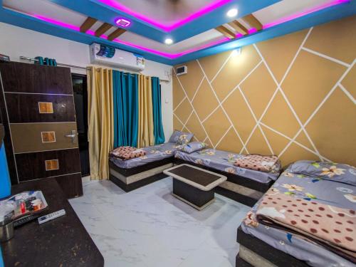 a room with two beds and a room with purple lights at Infinity Luxury Homestay in Garudeshwar