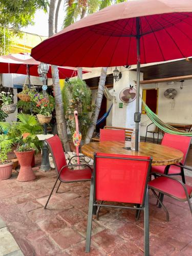 a table and chairs with a red umbrella on a patio at Hotel Nueva Granada in Santa Marta