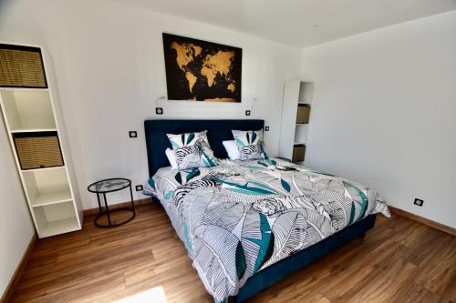 une chambre avec un lit avec une couette bleue et blanche dans l'établissement VILLA juganoma, à Royan