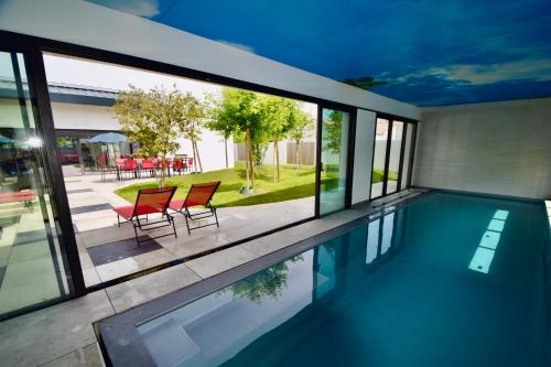 une maison avec une piscine avec deux chaises rouges dans l'établissement VILLA juganoma, à Royan