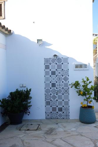 a blue wall with a mural on it next to two plants at Little Stone House in Lymbia
