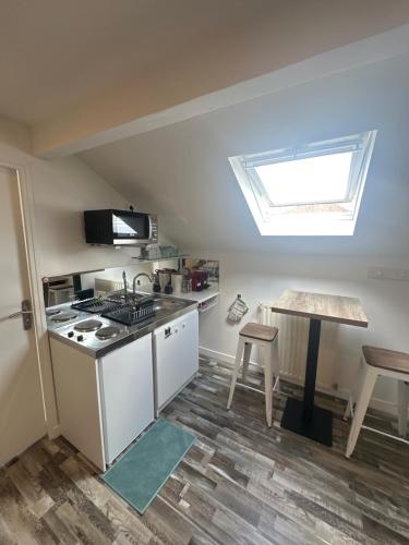 a kitchen with a stove and a sink and a table at Appartement Tremblay en France in Tremblay-En-France