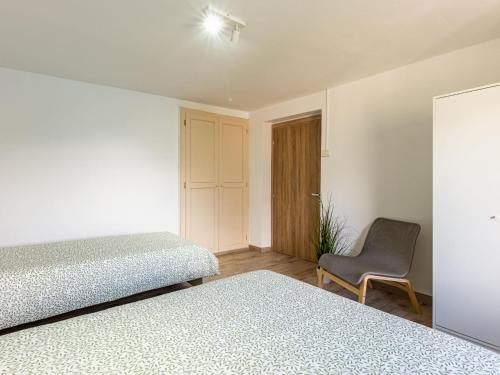 a bedroom with two beds and a chair at Holiday Home Miki Mhouse by Interhome in Verceia