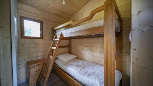 a bedroom with two bunk beds in a wooden cabin at Le chalet de DOMY in Granges-sur-Vologne