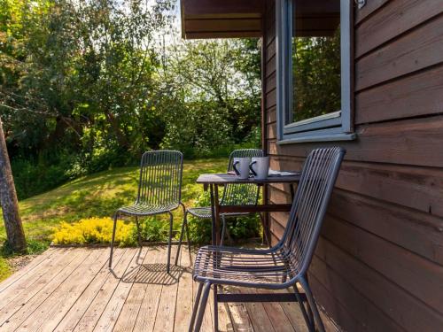 ローンセストンにあるChalet Bramley Hot Tub Lodge by Interhomeの小屋のベランダ(椅子2脚、テーブル1台付)