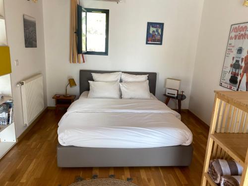 a bedroom with a bed with white sheets and pillows at Les Cabanons in Dardilly