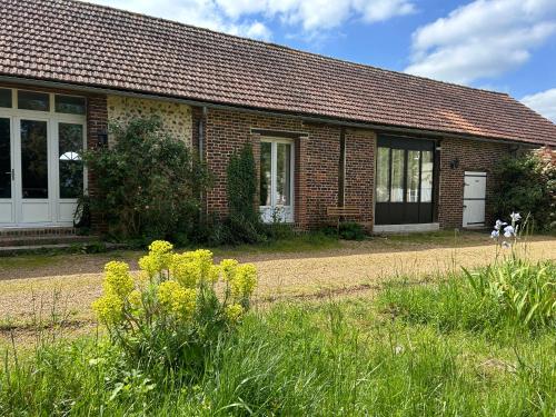 a brick house with a grass field in front of it at Gîte de L'Oliviade - Campagne & Confort in Billancelles
