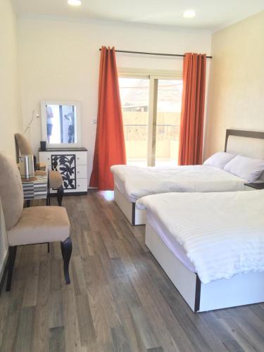 a bedroom with two beds and a desk and a window at Narmer Pyramids View in Cairo