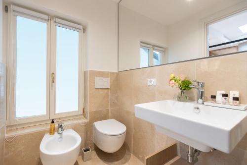 a bathroom with a white sink and a toilet at Amazing Piazza Venezia Suites in Rome