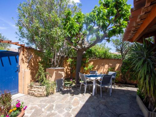 un patio avec une table et des chaises sous un arbre dans l'établissement Holiday Home Miramar by Interhome, à La Londe-les-Maures