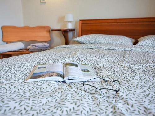 an open book on a bed with glasses on it at Holiday Home Andrea by Interhome in Brseč