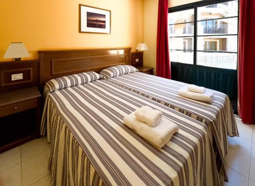 Habitación de hotel con 2 camas y toallas. en Complejo Las Tres Palmeras, en Valle Gran Rey