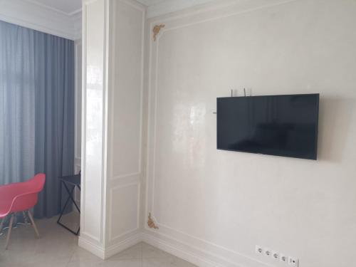 Апартаменты Аркадия في أوديسا: غرفة معيشة مع تلفزيون على الحائط