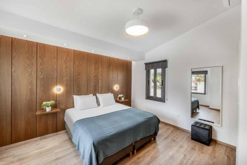 a bedroom with a large bed and wooden walls at Villa Christina Coral in Peyia