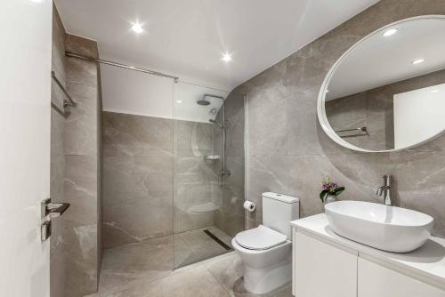 La salle de bains est pourvue de toilettes, d'un lavabo et d'un miroir. dans l'établissement Villa Christina Coral, à Peyia