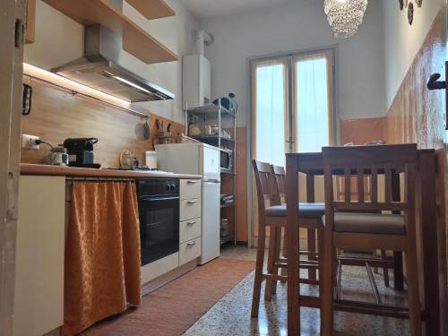 una cucina con piano cottura e alcune sedie di La casetta di Elena - Sondrio Valtellina a Sondrio