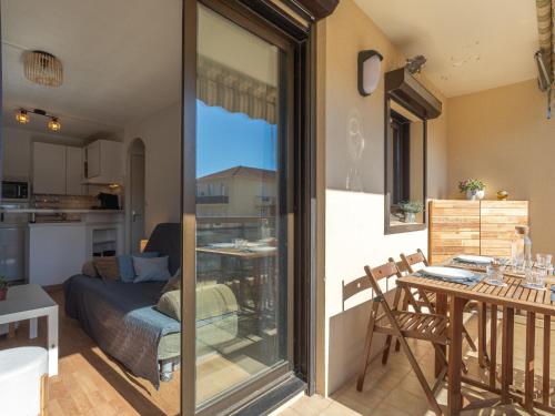 Una sala de estar con una mesa y una cocina. en Apartment Saint James-14 by Interhome, en Le Lavandou