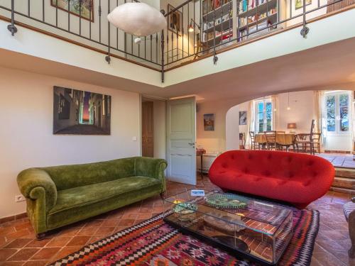 - un salon avec un canapé vert et un fauteuil rouge dans l'établissement Holiday Home Le Clos du Pierredon by Interhome, à Grimaud