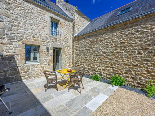 - une terrasse avec une table et des chaises devant un bâtiment en pierre dans l'établissement Holiday Home Colary by Interhome, à Carnac