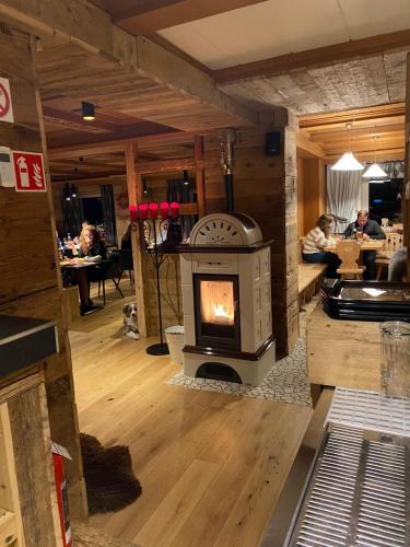 a living room with a wood stove in the middle at Hotel Almhof in San Candido