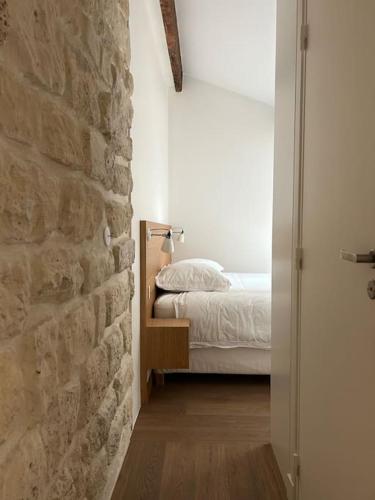 une chambre avec un lit et un mur en pierre dans l'établissement Elegant loft-duplex pour 2/3 personnes, à Paris