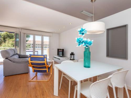 Una sala de estar con una mesa y un jarrón con flores azules. en Apartment Chesa by Interhome, en Benicarló