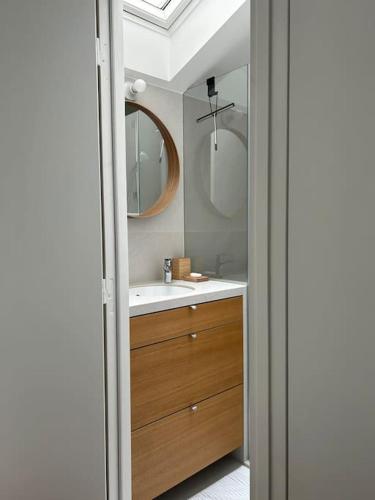 une salle de bain avec un lavabo et un miroir dans l'établissement Elegant loft-duplex pour 2/3 personnes, à Paris